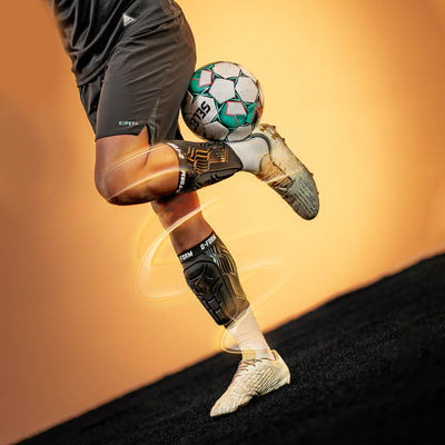 Person kicking a soccer ball with a blurred background