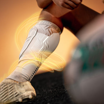 Person wearing a compression sleeve on their leg with a blurred background