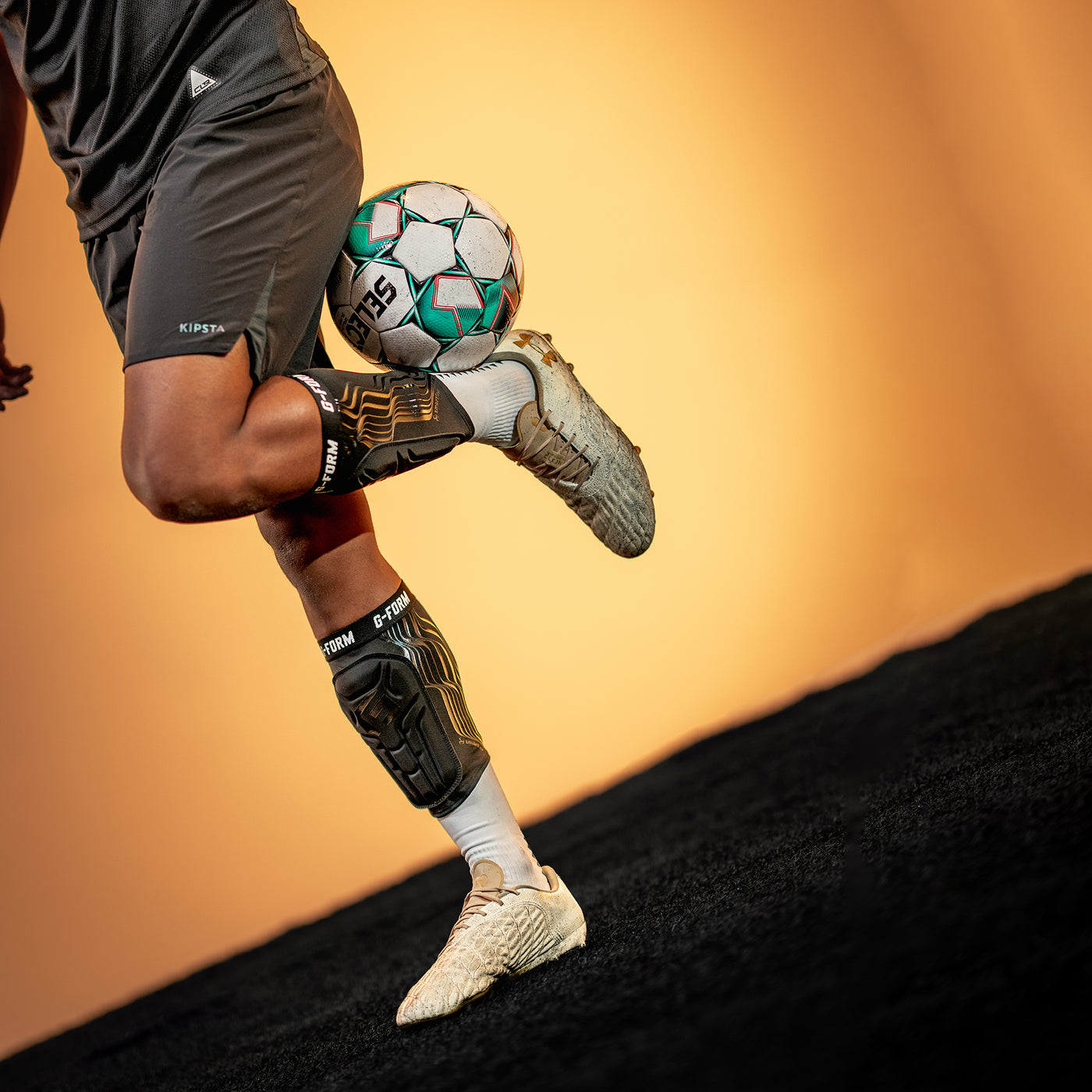 Person kicking a soccer ball with a blurred background